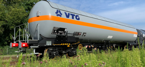 Grauer Kesselwagen mit orangenem Streifen rund herum